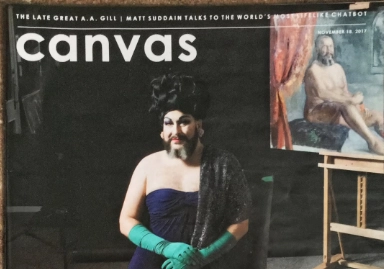 This image shows the cover of a magazine titled 'Canvas,' featuring a person in elegant drag attire, including a strapless navy gown, a black shawl, and green gloves. They are posed with a confident expression in front of a painting of a nude figure in an artist's studio setting. The text at the top mentions 'The late great A.A. Gill' and an article involving 'Matt Suddain,' with a publication date of November 19, 2017.